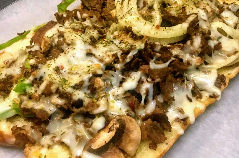 Loaded steak and cheese grinder on a toasted artisan hoagie roll